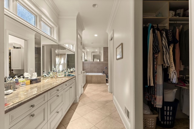 bathroom featuring vanity, tile patterned floors, crown molding, and tiled tub