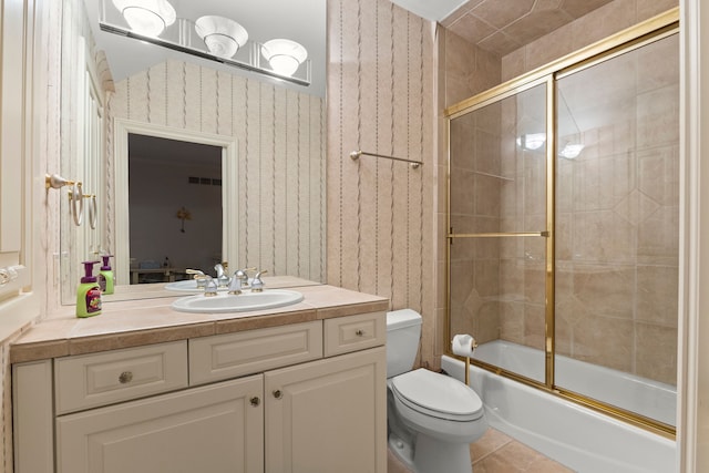 full bathroom with tile patterned floors, toilet, vanity, and combined bath / shower with glass door