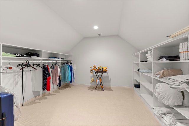 walk in closet with lofted ceiling and light carpet