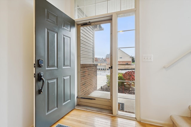 foyer entrance featuring light wood-style flooring and baseboards