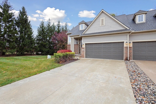 view of front of home featuring driveway, a garage, roof with shingles, a front lawn, and brick siding