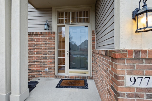 view of exterior entry with brick siding