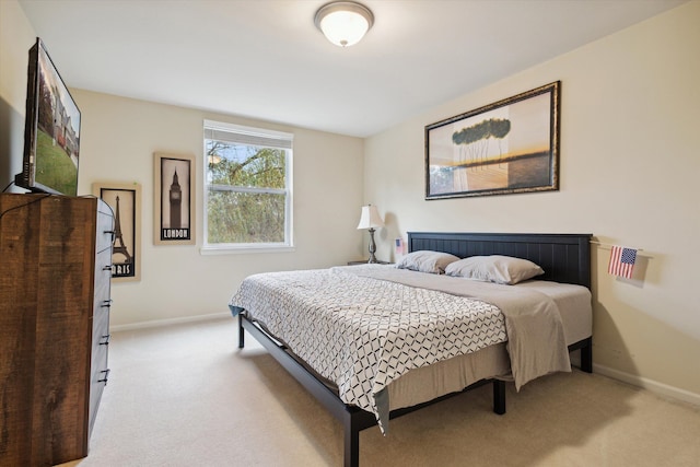 bedroom with light carpet and baseboards