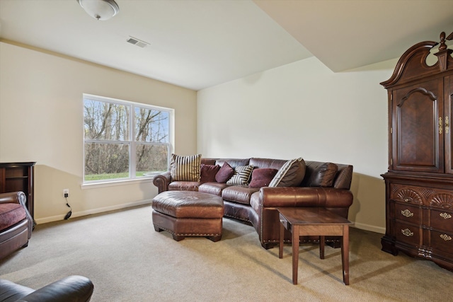 living area with light carpet, visible vents, and baseboards