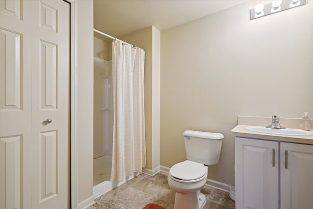 full bathroom with baseboards, a shower stall, toilet, and vanity