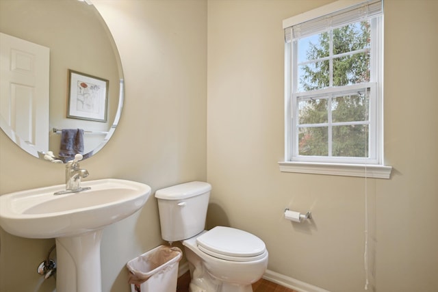 half bath with toilet and baseboards