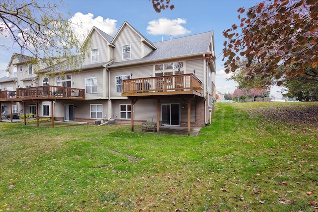 rear view of property featuring a deck and a lawn