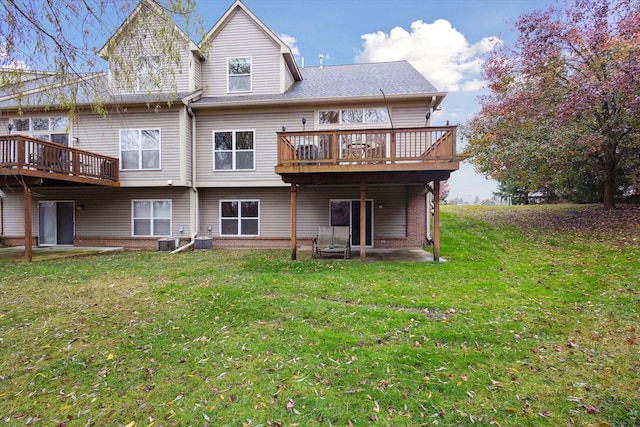 back of house featuring cooling unit, brick siding, a yard, and a deck