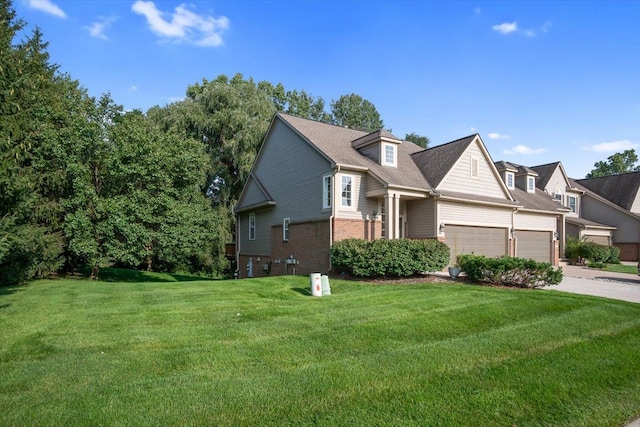 view of front of house featuring an attached garage, a front lawn, concrete driveway, and brick siding