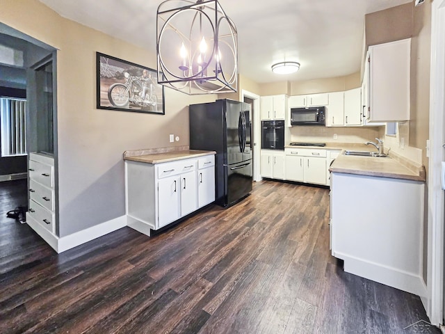 kitchen with dark wood-type flooring, sink, black appliances, pendant lighting, and white cabinetry