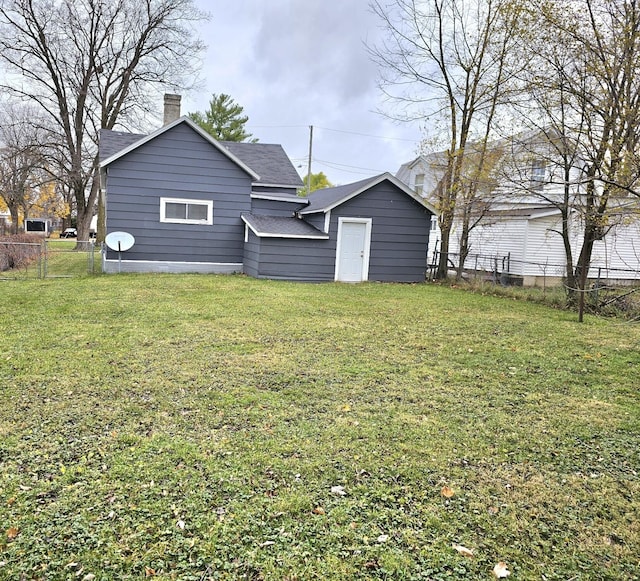 rear view of house featuring a yard