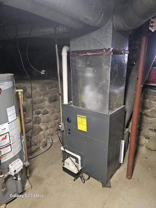 utility room featuring heating unit and gas water heater