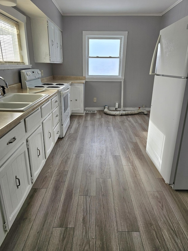 kitchen with white cabinetry, a wealth of natural light, white appliances, and light hardwood / wood-style flooring