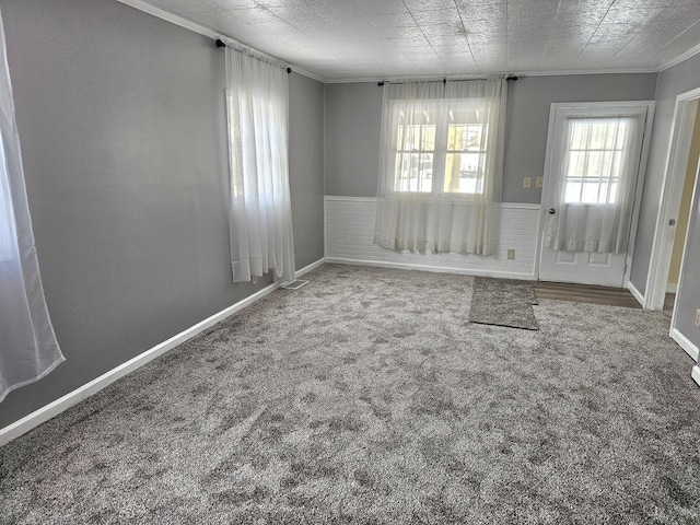 unfurnished dining area featuring ornamental molding and carpet flooring