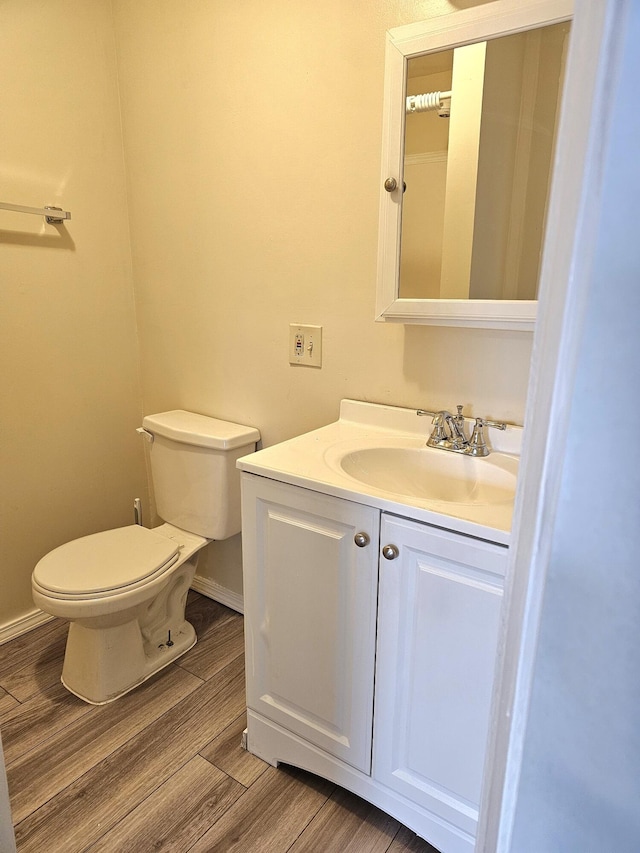 bathroom with vanity, hardwood / wood-style flooring, and toilet