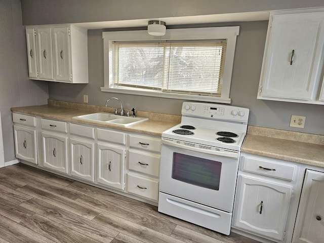 kitchen featuring sink, white electric range, white cabinets, and light hardwood / wood-style flooring