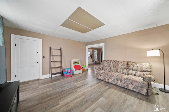 living room featuring hardwood / wood-style floors and a drop ceiling