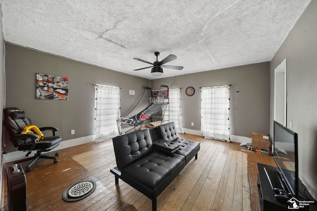 interior space featuring ceiling fan, hardwood / wood-style flooring, and a textured ceiling