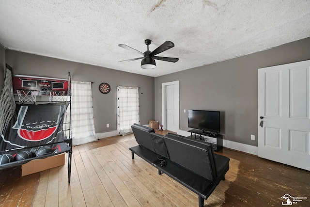 living room with hardwood / wood-style flooring, ceiling fan, and a textured ceiling