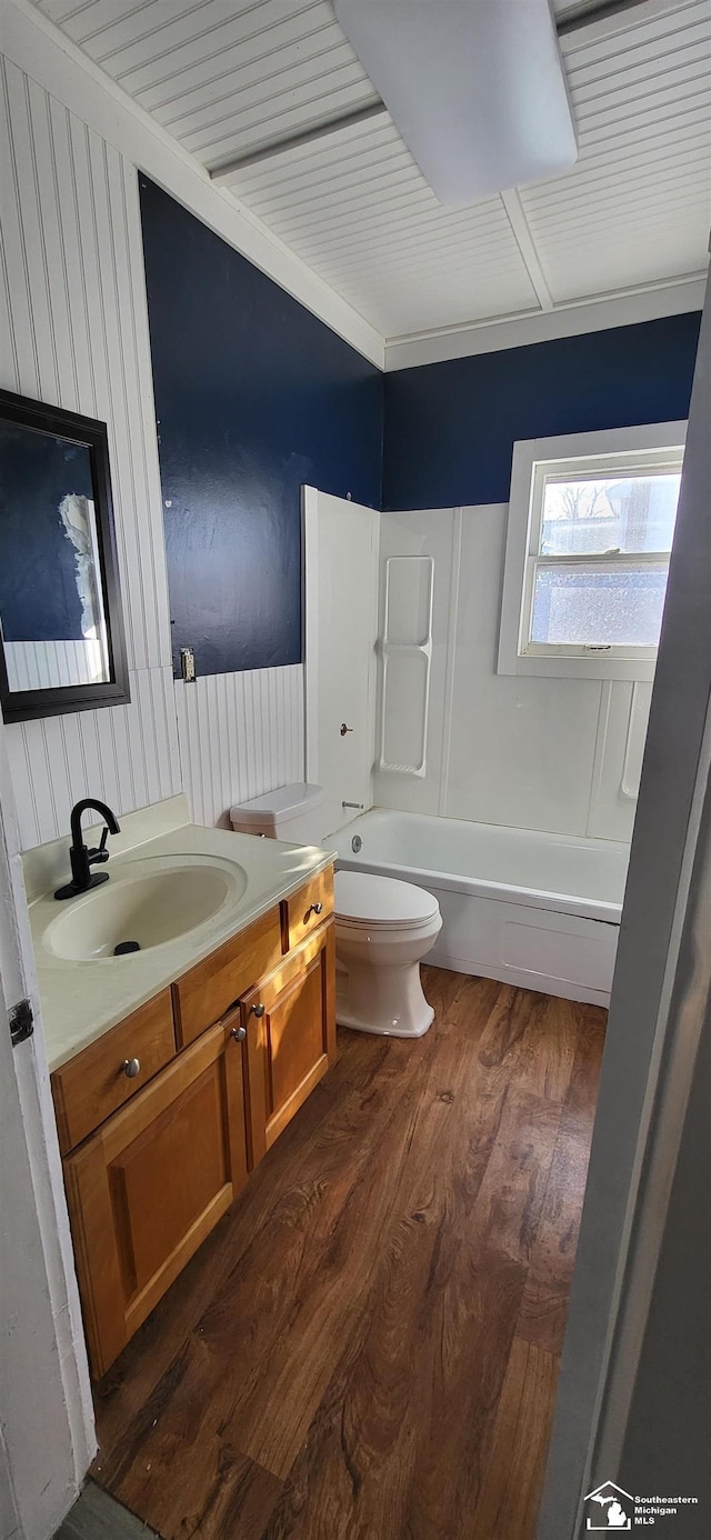 full bathroom featuring hardwood / wood-style flooring, vanity, toilet, and  shower combination