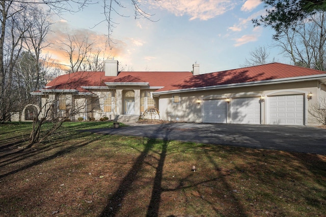 mediterranean / spanish-style home with a garage and a lawn