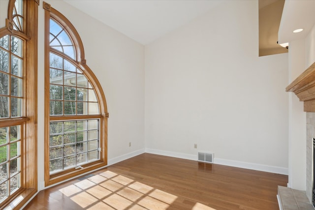 interior space featuring hardwood / wood-style floors and a tiled fireplace