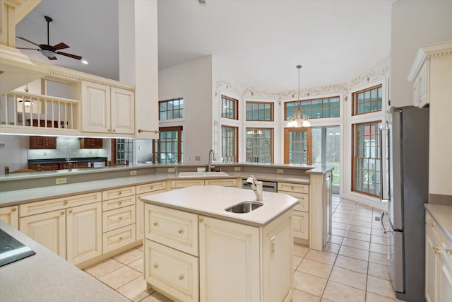 kitchen featuring sink, an island with sink, decorative light fixtures, ceiling fan with notable chandelier, and appliances with stainless steel finishes