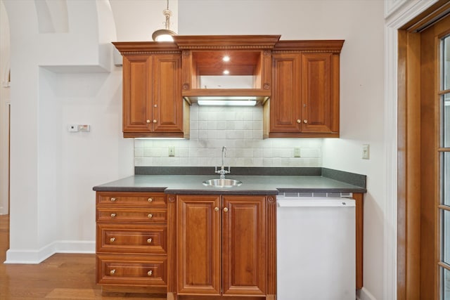 kitchen with tasteful backsplash, sink, pendant lighting, hardwood / wood-style flooring, and dishwasher