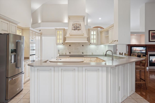 kitchen featuring cream cabinetry, plenty of natural light, high end fridge, and sink