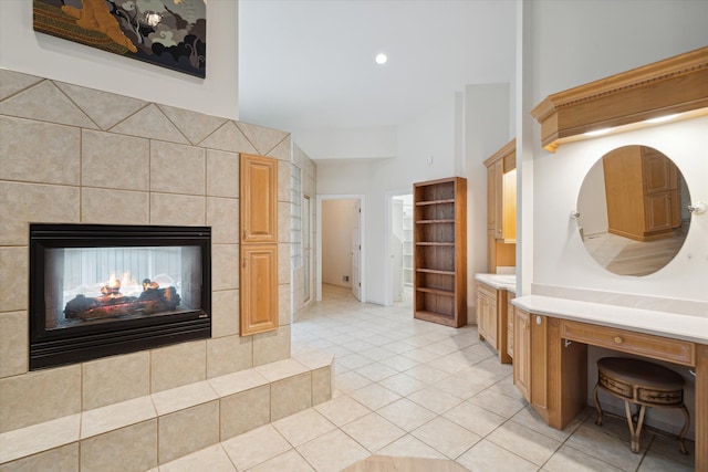 bathroom featuring a multi sided fireplace, tile patterned flooring, and tile walls