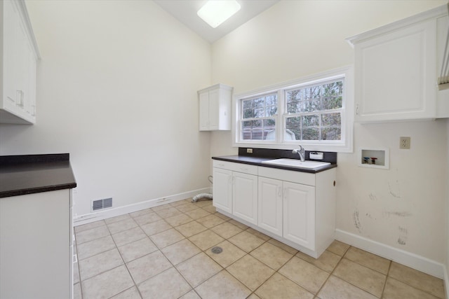 kitchen with sink, white cabinets, light tile patterned floors, and high vaulted ceiling