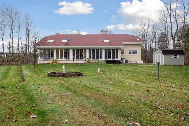 back of property featuring a lawn, a storage shed, and a sunroom