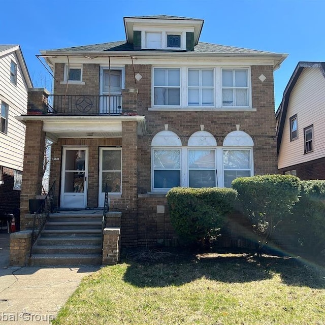 view of front of property featuring a balcony and a front yard