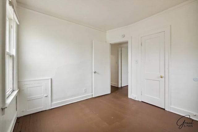 empty room with dark wood-type flooring and ornamental molding