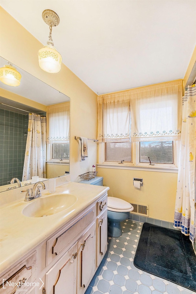 bathroom featuring plenty of natural light, toilet, and vanity