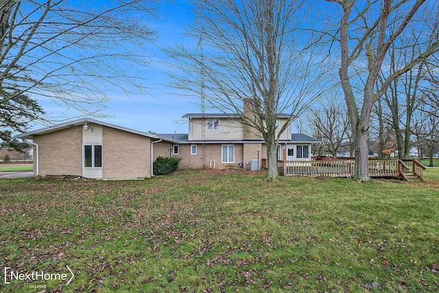 rear view of house with a yard and a deck