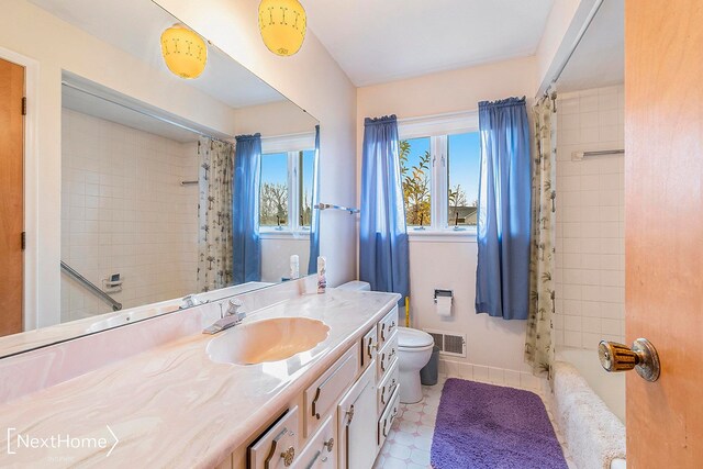 full bathroom with vanity, toilet, and shower / tub combo