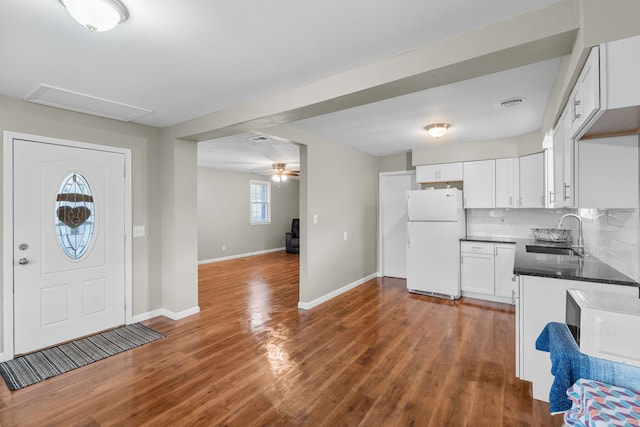 kitchen featuring sink, white cabinets, dark hardwood / wood-style floors, and white refrigerator