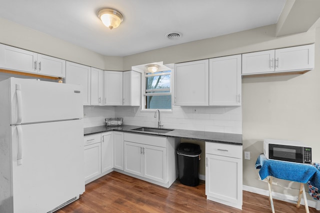 kitchen featuring white cabinets, white fridge, dark wood-type flooring, and sink