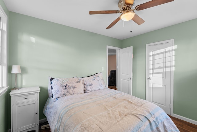 bedroom with dark hardwood / wood-style flooring and ceiling fan