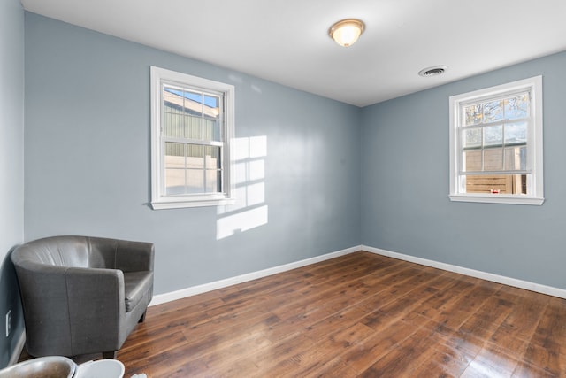 sitting room with plenty of natural light and dark hardwood / wood-style floors