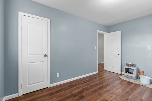 unfurnished bedroom featuring dark hardwood / wood-style flooring