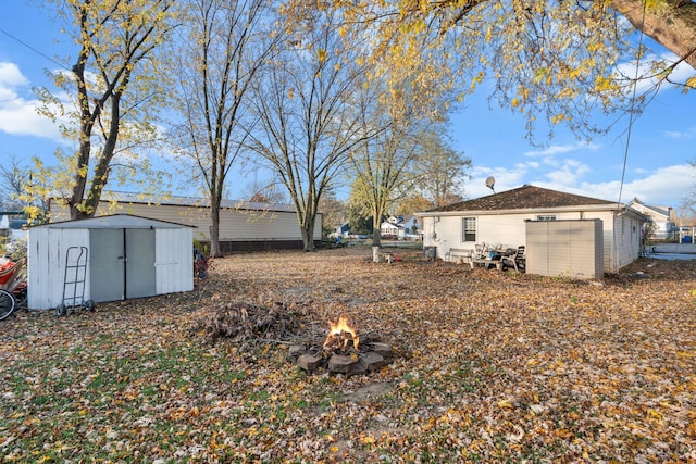 view of yard with a fire pit and a storage unit