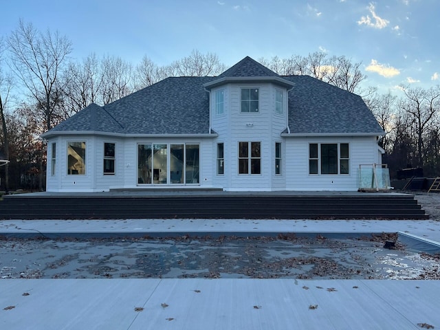 back of property featuring roof with shingles and a wooden deck