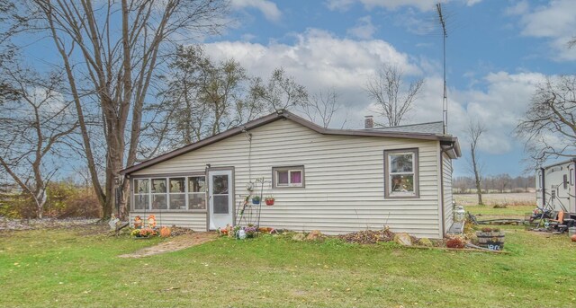 967 Newton Rd, Quincy, MI 49082 - rear view of house with a yard, a sunroom, and a chimney