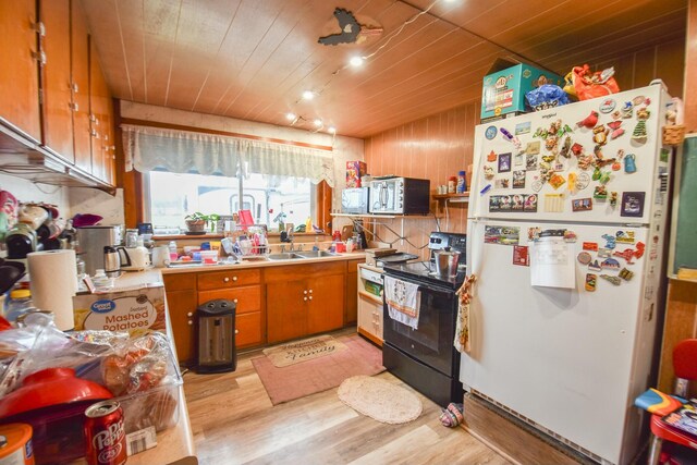 967 Newton Rd, Quincy, MI 49082 - kitchen with freestanding refrigerator, electric range, light wood-style flooring, stainless steel microwave, and brown cabinetry