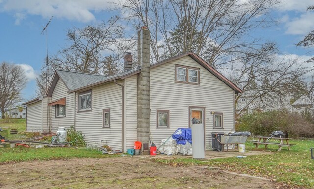 967 Newton Rd, Quincy, MI 49082 - back of house featuring a chimney and roof with shingles