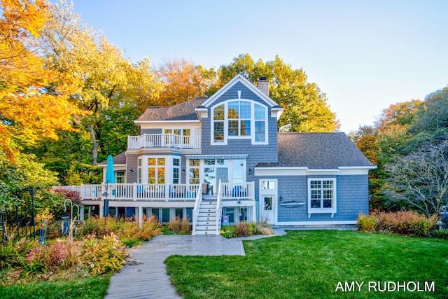 1749 Sunset Point Dr, Norton Shores, MI 49441 - rear view of house featuring a balcony, a chimney, a lawn, a deck, and stairs
