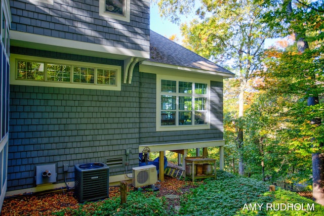 1749 Sunset Point Dr, Norton Shores, MI 49441 - view of property exterior featuring ac unit, cooling unit, and roof with shingles