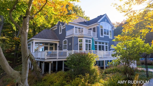 1749 Sunset Point Dr, Norton Shores, MI 49441 - rear view of house with roof with shingles, a wooden deck, a balcony, and a sunroom